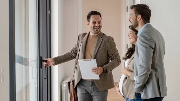 A sales agent walking a couple through a new home